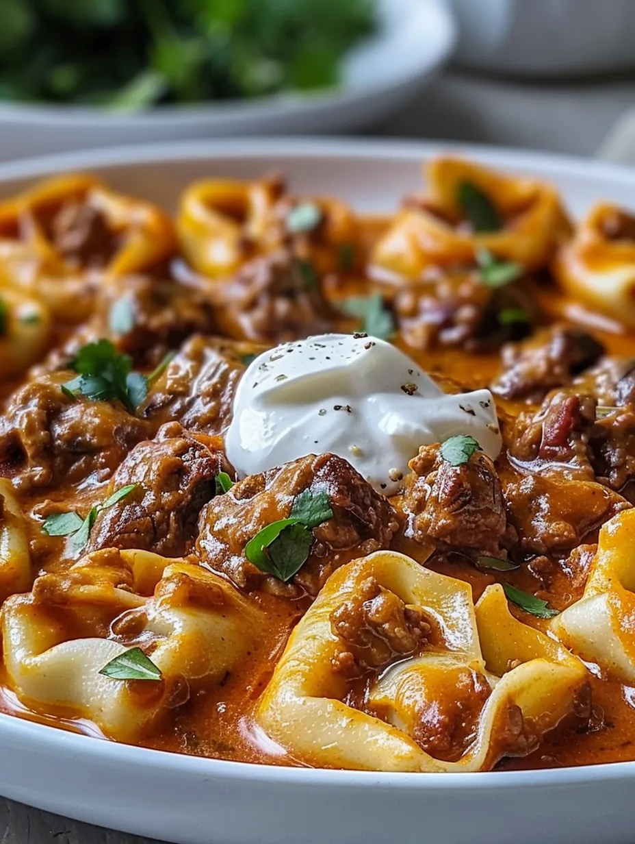 Un primer plano de una deliciosa tortellini de carne con salsa de enchilada con queso.