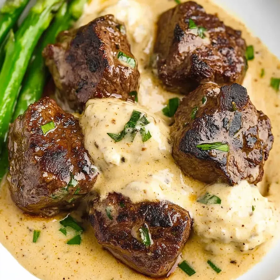 Un plato de trozos de filete con mantequilla de ajo.