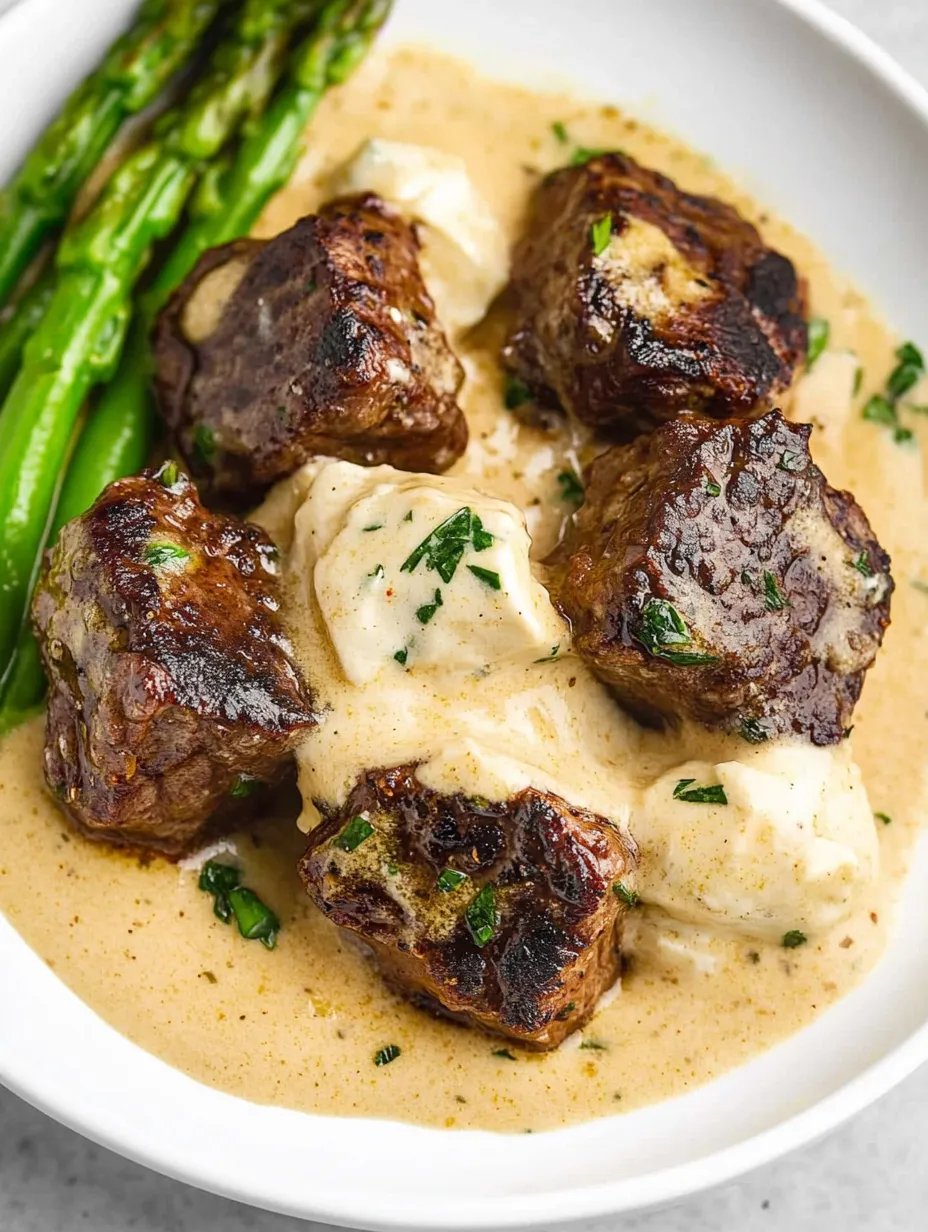 Un plato de trozos de bistec con mantequilla de ajo.