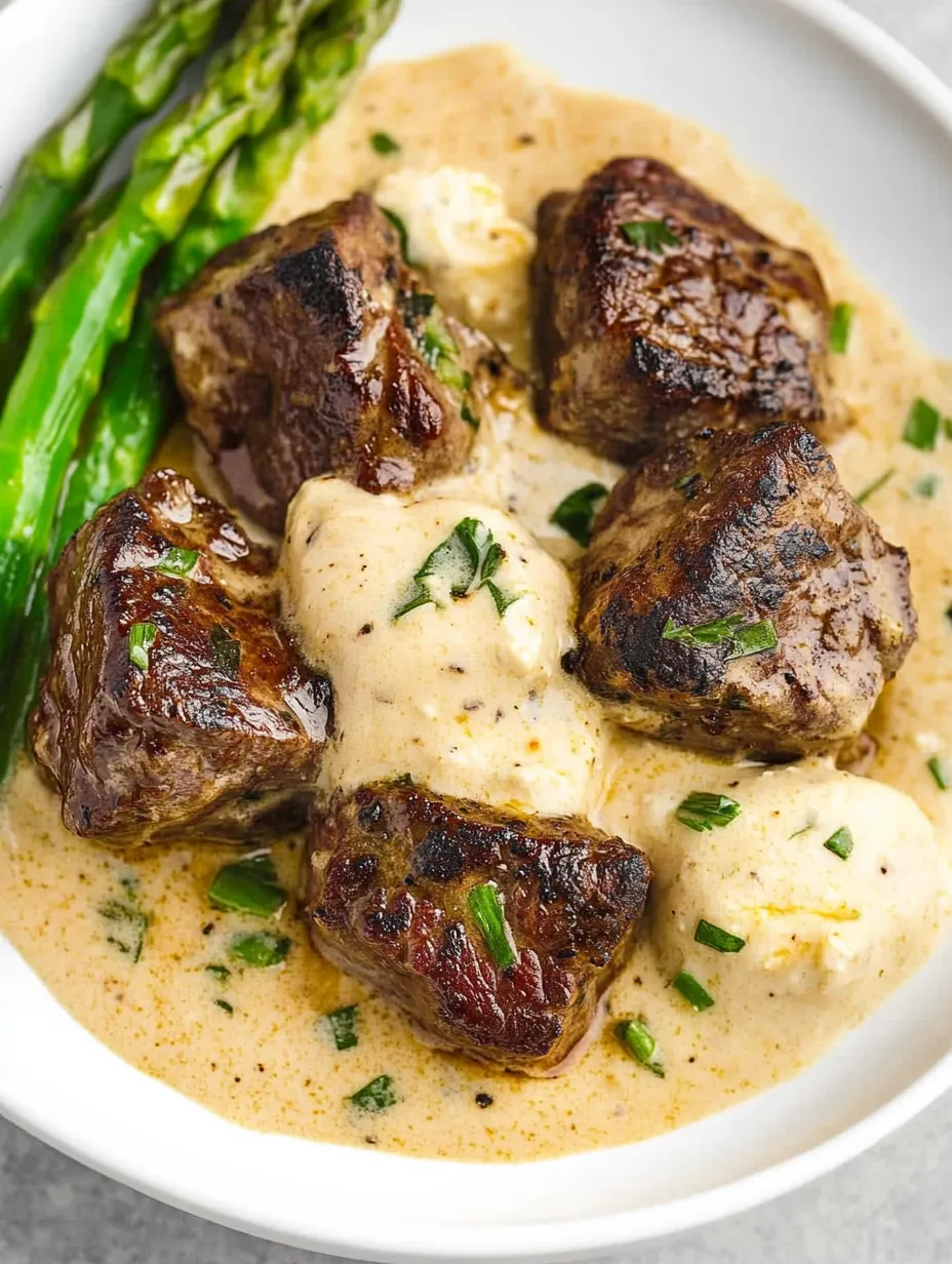 Un plato de trozos de bistec con mantequilla de ajo.