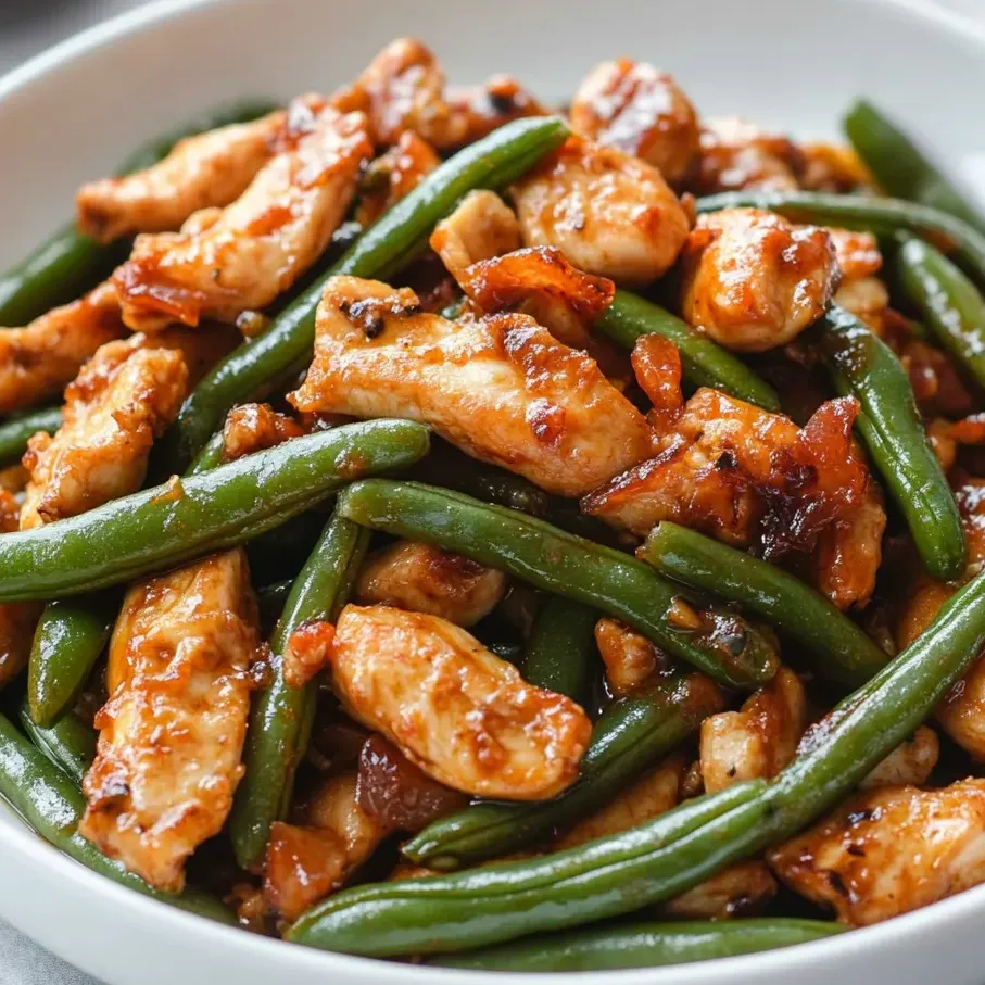 A plate of chicken with green beans.