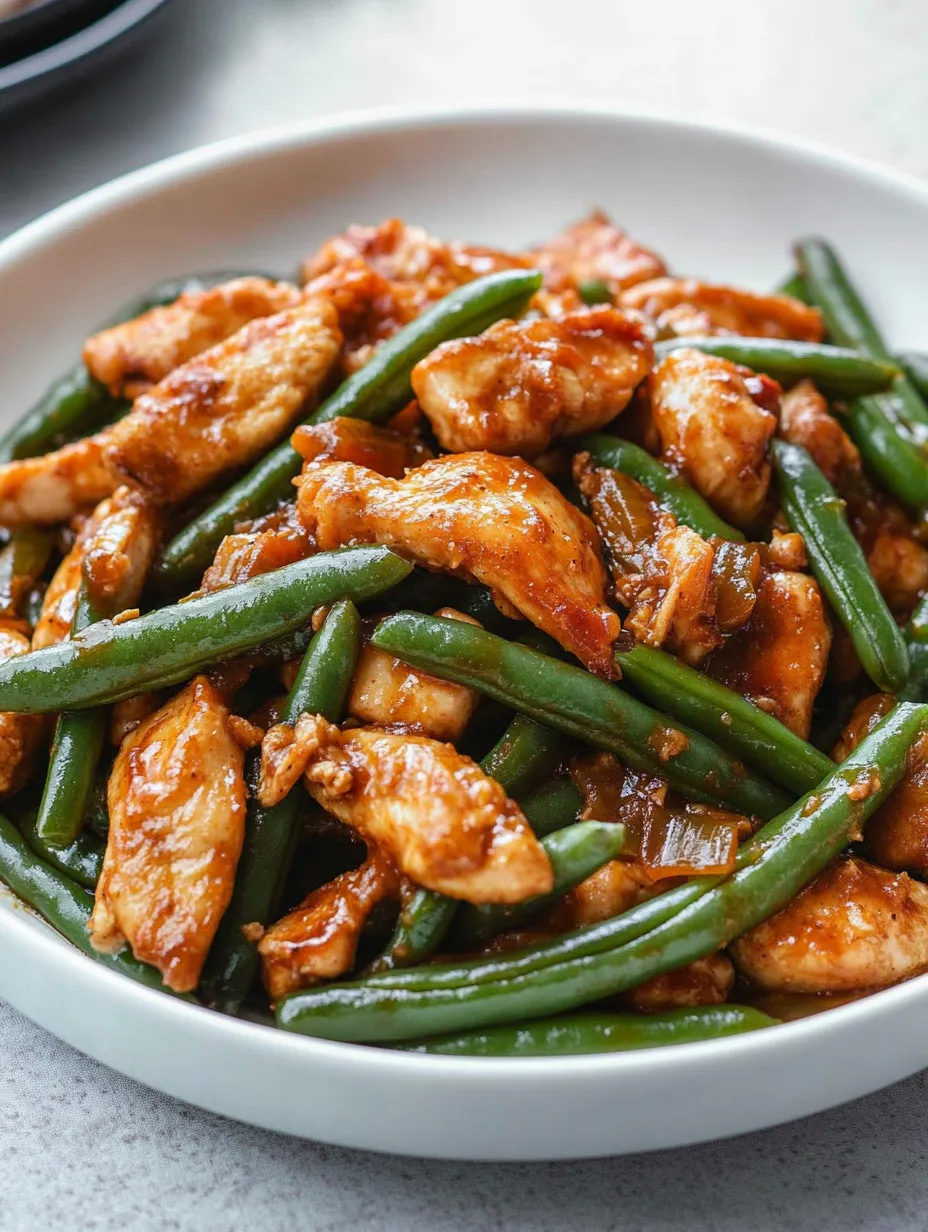 Un plato de pollo con judías verdes.