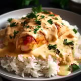 Un plato de arroz y pollo cubierto con salsa cremosa.
