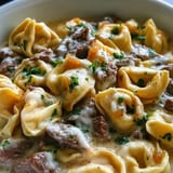 Un plato de tortellini con bistec en salsa cremosa de provolone.