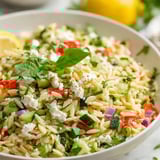 Un cuenco de arroz con verduras y queso feta.