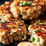 Un plato con tortitas de atún y mayonesa.