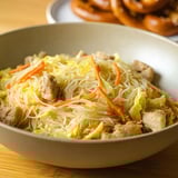 Un plato de pancit con carne y verduras.
