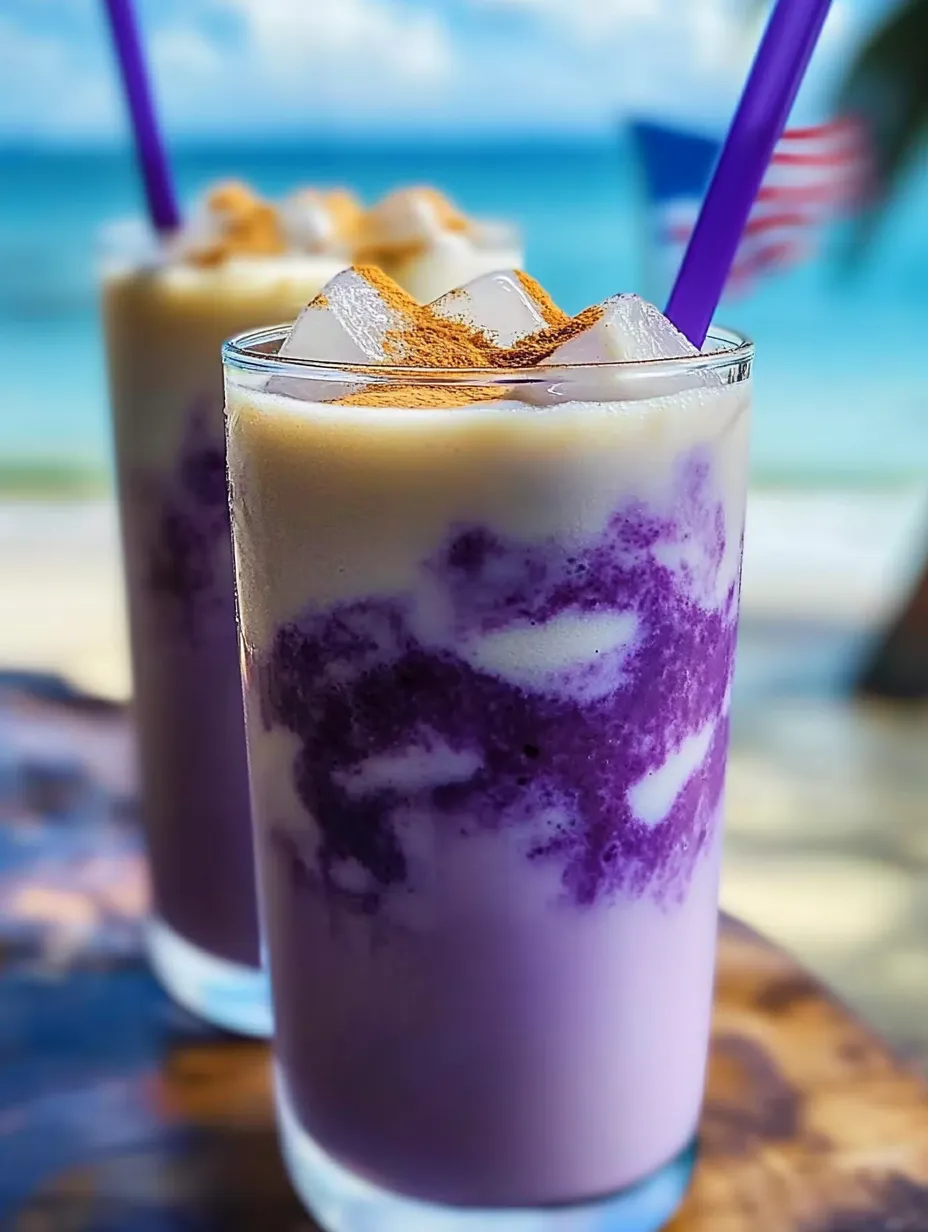Un vaso de bebida morada con hielo y una pajita.