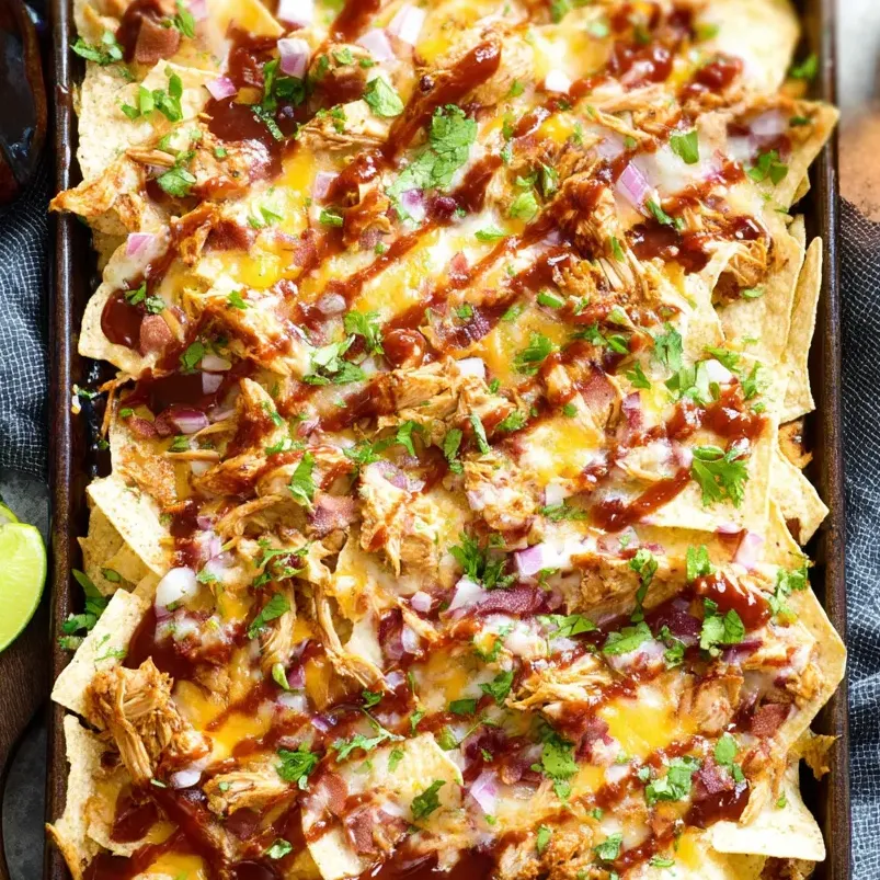 Una bandeja de nachos con pollo BBQ.