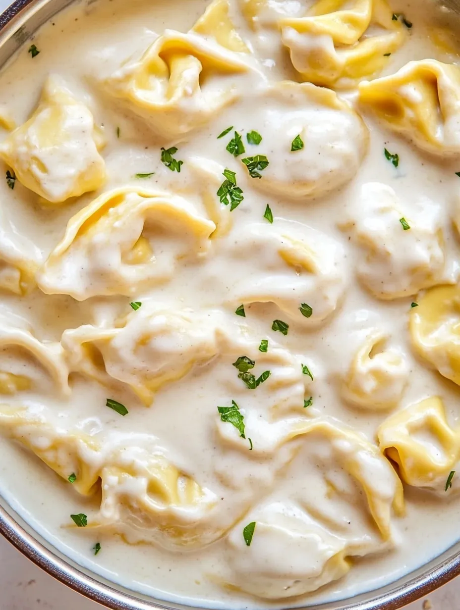 Un plato humeante de tortellini al ajo y parmesano.
