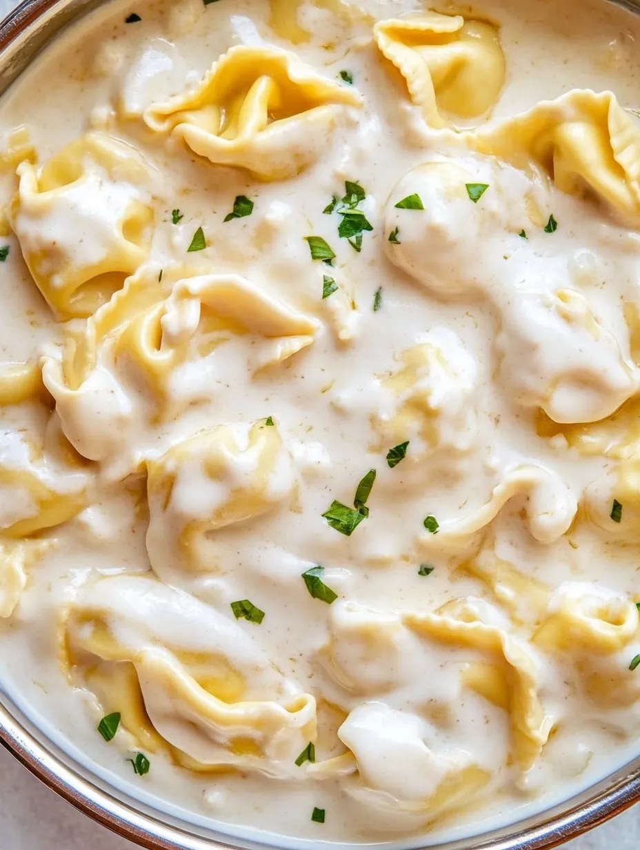 Un plato de tortellini al ajito y parmesano.