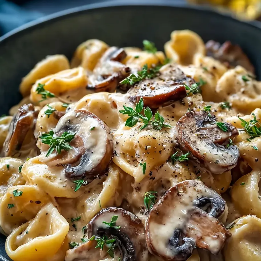 Un plato de pasta con champiñones y hierbas.