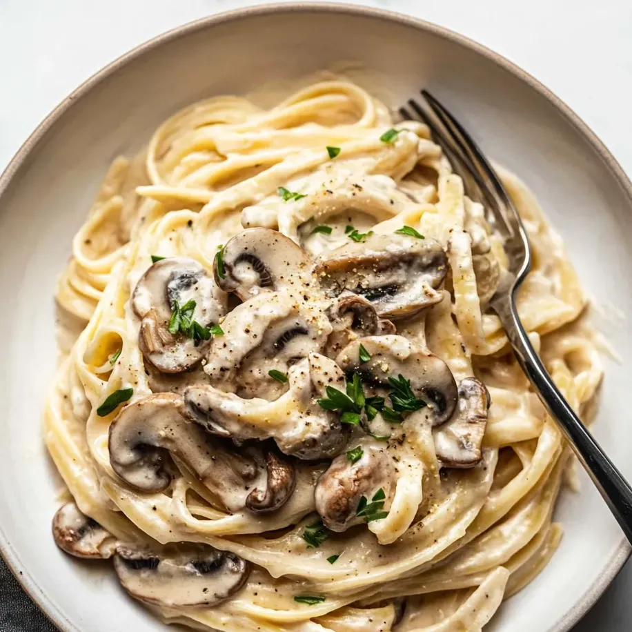 Un plato de pasta con champiñones y hierbas.