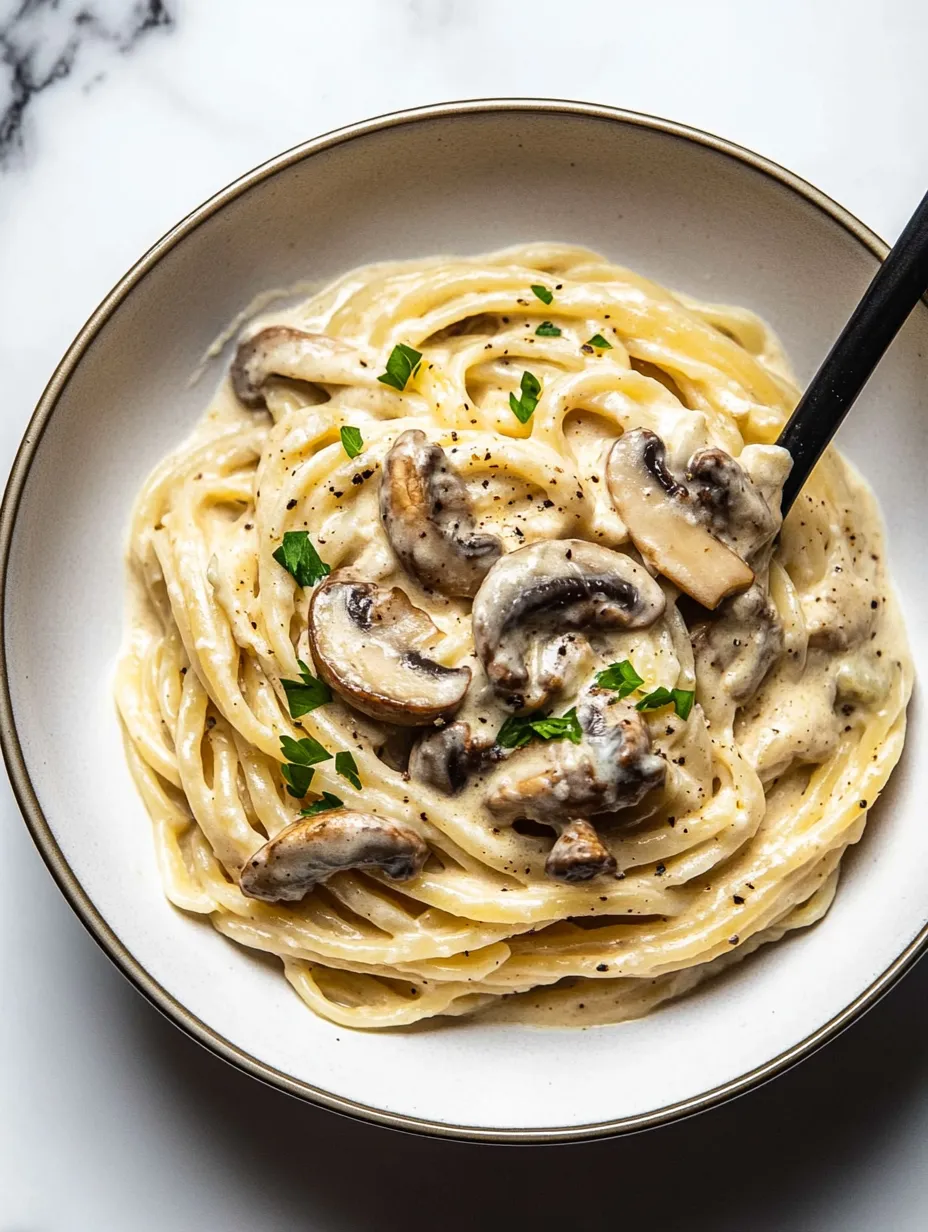 Un bowl de pasta con champiñones y hierbas.