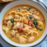 Un plato de sopa toscana cremosa con pollo.