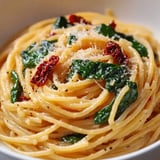 Un bol de pasta con espinaca y queso.