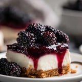 Porción de tarta de queso fría con moras encima.