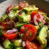 Un bol con tomates, pepinos, cebolla y pimientos en rodajas.