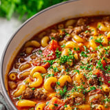 Un tazón de sopa con fideos y carne.