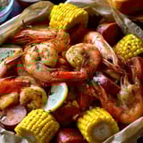 Un plato con camarones y maíz.