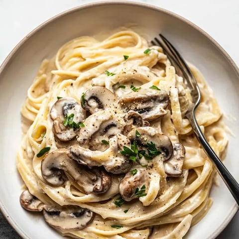 Un plato de pasta con champiñones y hierbas.
