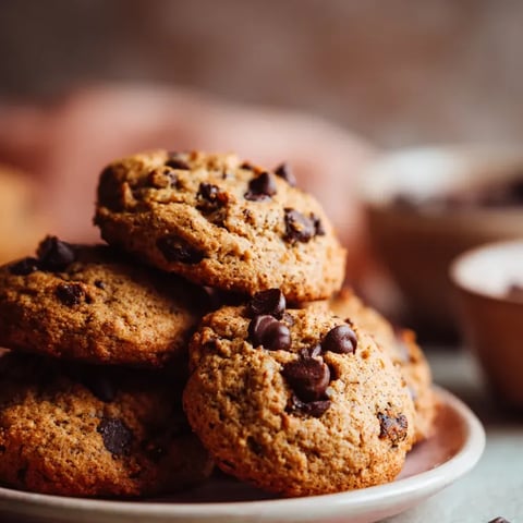 Una bandeja llena de muffins y chips de chocolate por encima.